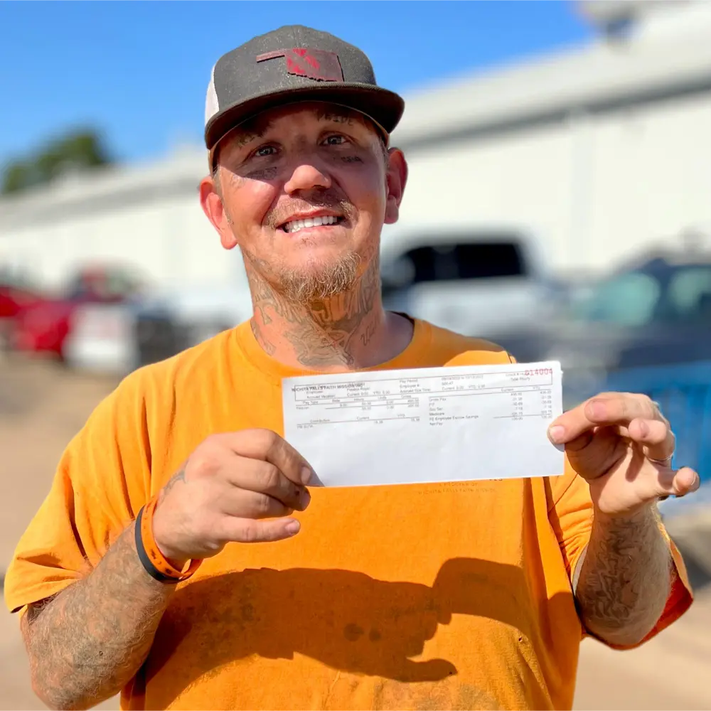 Preston holding his first paycheck